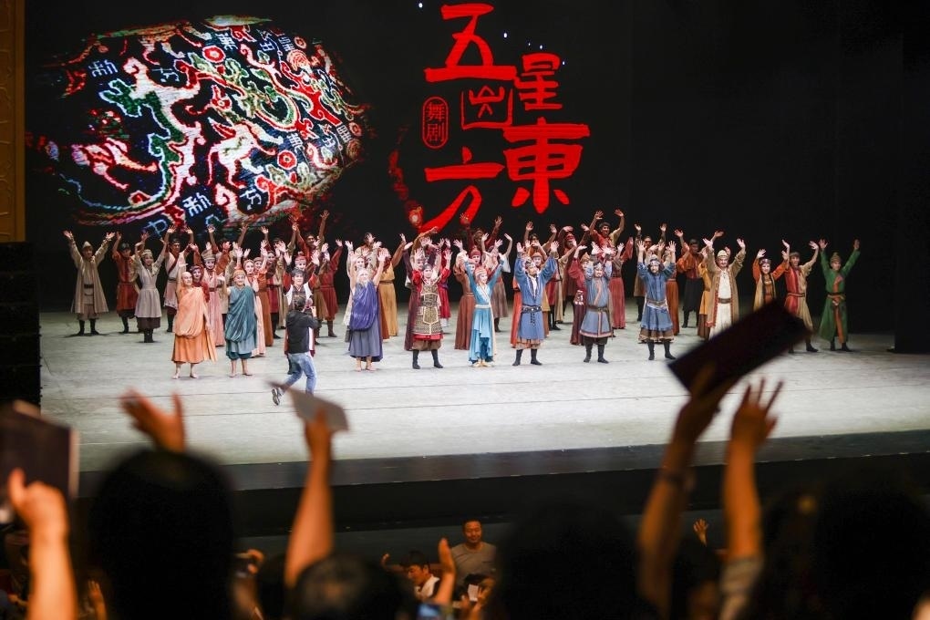 2023年7月31日，新疆和田地區(qū)新玉歌舞團在烏魯木齊京劇院演出舞劇《五星出東方》后和觀眾互相揮手致意。這場演出是第六屆中國新疆國際民族舞蹈節(jié)的參演劇目之一，曾榮獲國家“文華獎”等。新華社記者 郝昭 攝