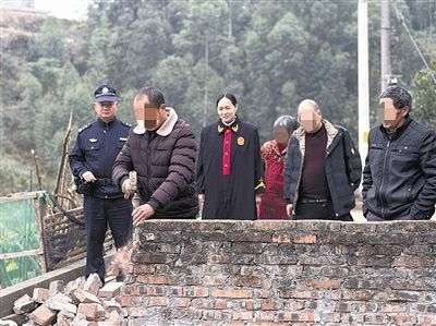  圖③：庭審結(jié)束后，在法官的見證下，陳某在院壩邊重新開鑿一條通道。