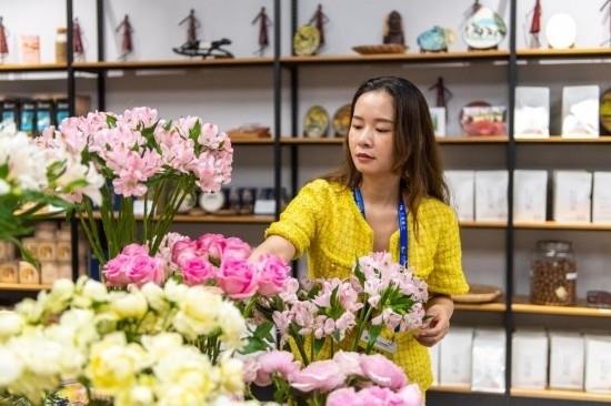 2023年7月1日，在位于湖南省長沙市的湖南高橋大市場，中非經(jīng)貿(mào)博覽會常設(shè)展館展區(qū)肯尼亞館工作人員在整理產(chǎn)自非洲的鮮花。新華社記者 陳思汗 攝