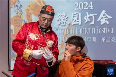 1月28日，在上海豫園舉行的民俗活動上，美國馬斯卡廷中學(xué)學(xué)生在非遺傳承人的指導(dǎo)下吹糖偶。 新華社記者 王翔 攝