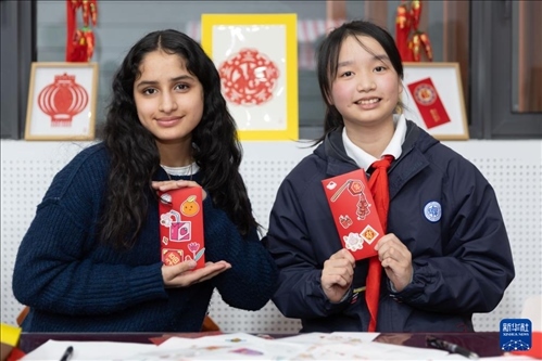 1月28日，美國馬斯卡廷中學(xué)學(xué)生（左）和復(fù)旦大學(xué)第二附屬學(xué)校學(xué)生展示互相送出的寫有寄語祝福的紅包。 新華社記者 王翔 攝