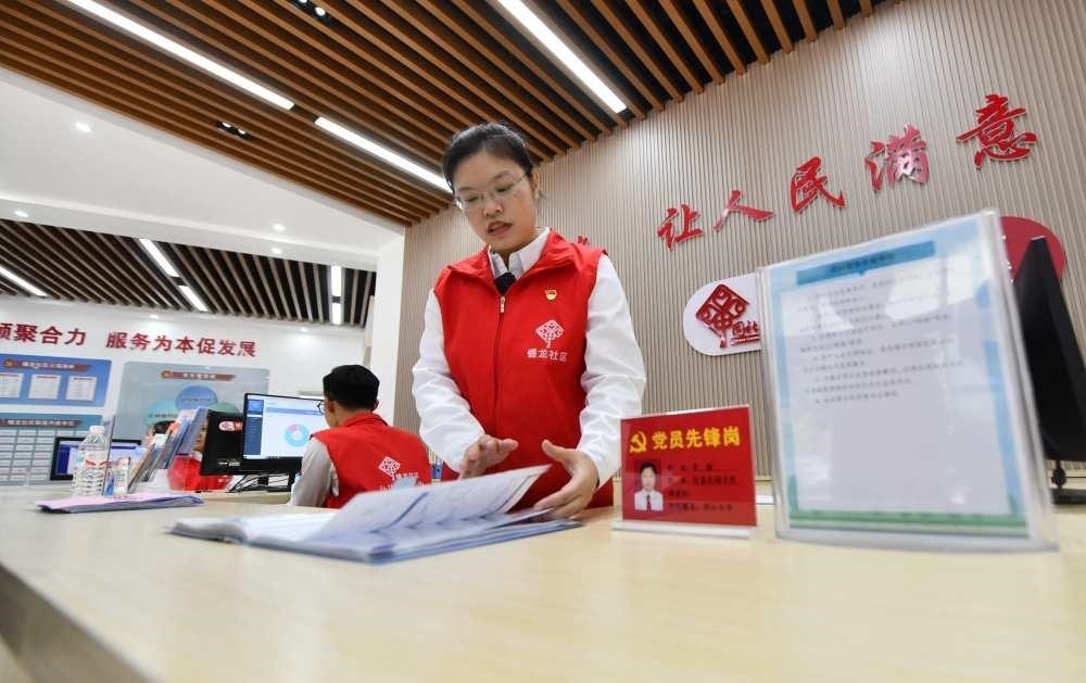 △2023年12月14日，廣西南寧市蟠龍社區(qū)，工作人員在為居民服務(wù)。