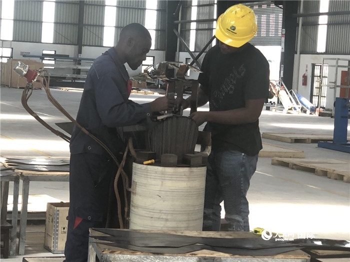 經(jīng)貿(mào)合作區(qū)廠房內(nèi)，當(dāng)?shù)毓と苏诰o張作業(yè)。人民網(wǎng)記者 黃培昭攝