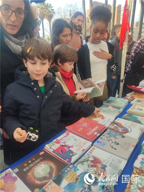 印刷精美的中國傳統(tǒng)文化叢書吸引了小游客的注意。人民網(wǎng)記者鄭彬攝