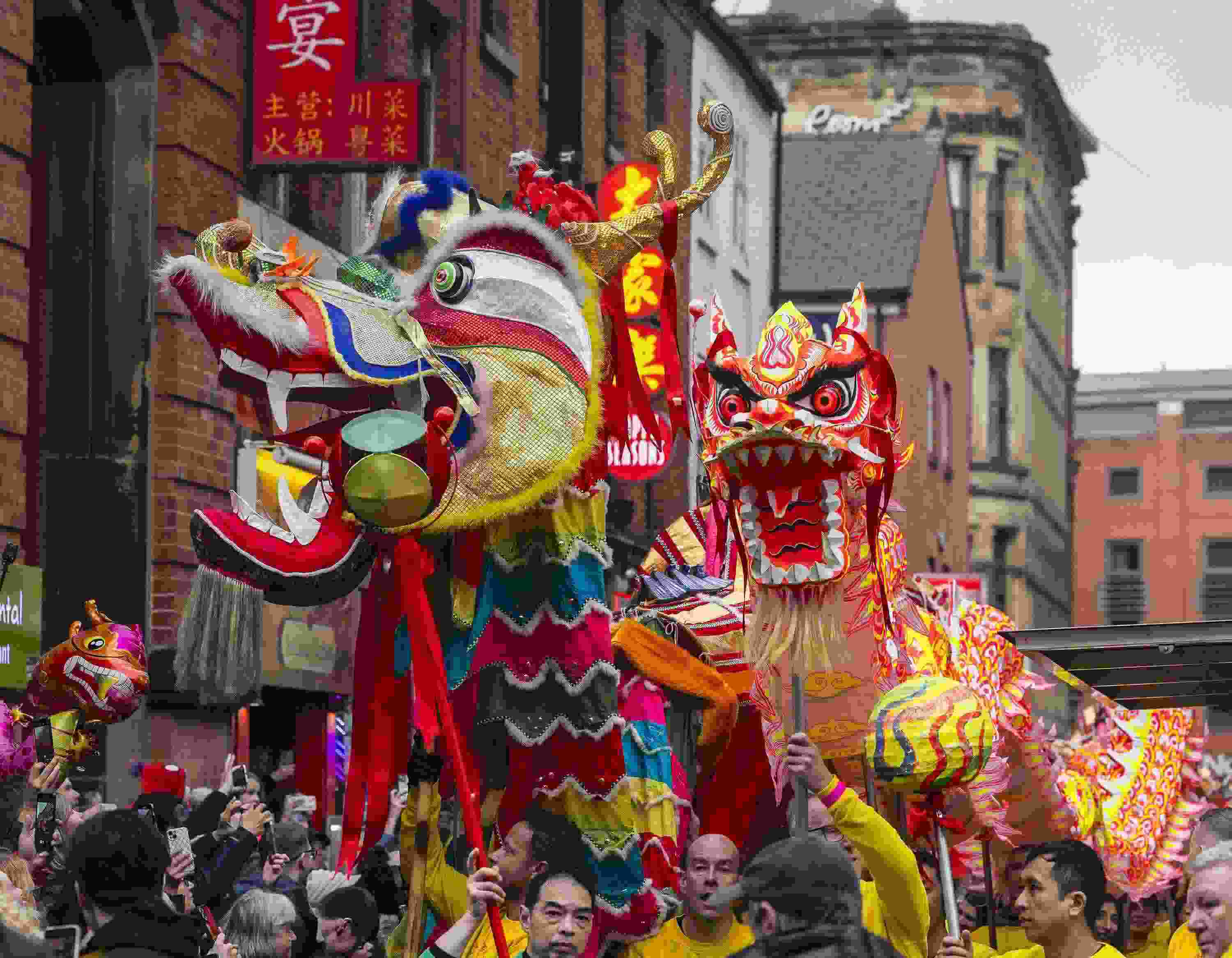 △ 當(dāng)?shù)貢r(shí)間2024年2月11日，英國(guó)曼徹斯特，表演者進(jìn)入中國(guó)城，參加中國(guó)農(nóng)歷龍年春節(jié)的慶祝活動(dòng)。