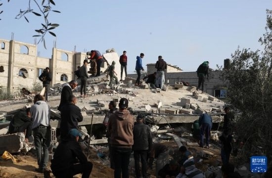  3月3日，在加沙地帶南部城市拉法，人們查看被以軍空襲破壞的建筑。新華社發(fā)（哈立德·奧馬爾攝）