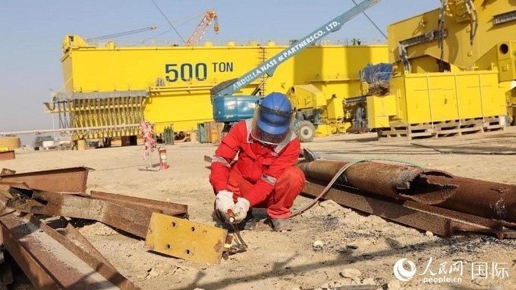 工人正在龍門(mén)吊吊裝現(xiàn)場(chǎng)切割金屬件。人民網(wǎng)記者管克江攝