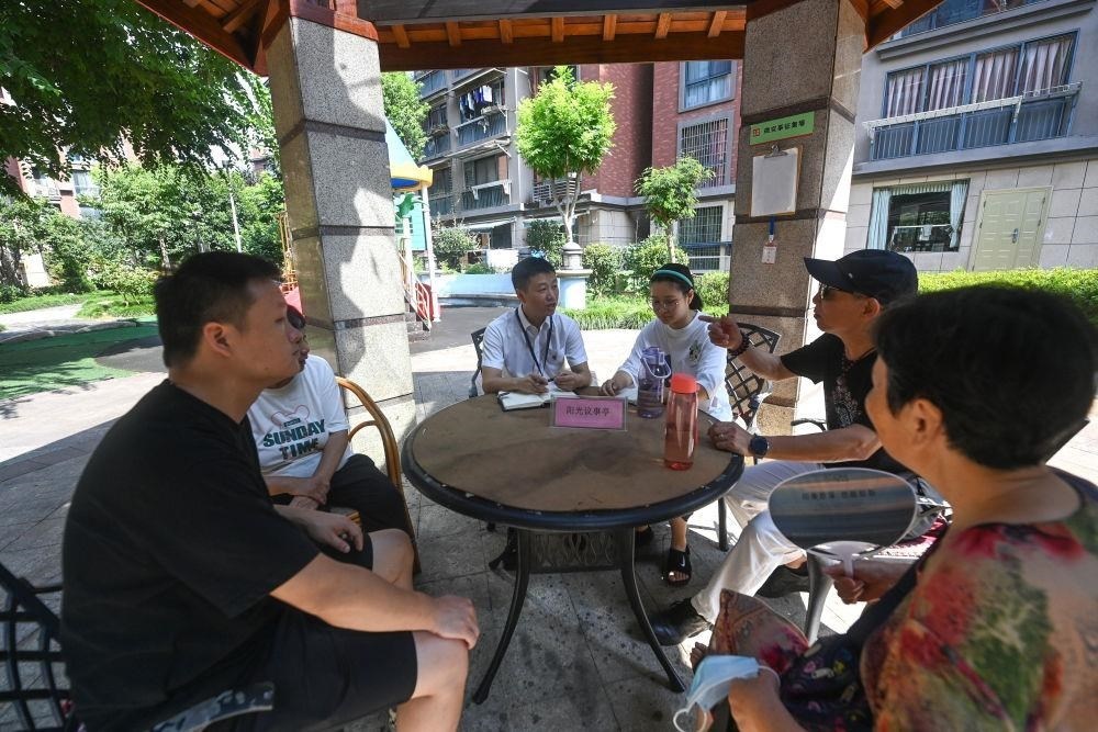 △2023年7月21日，在位于浙江杭州臨安區(qū)錦南街道水岸陽光小區(qū)的陽光議事廳，街道干部在聽取居民們反映的問題及意見。