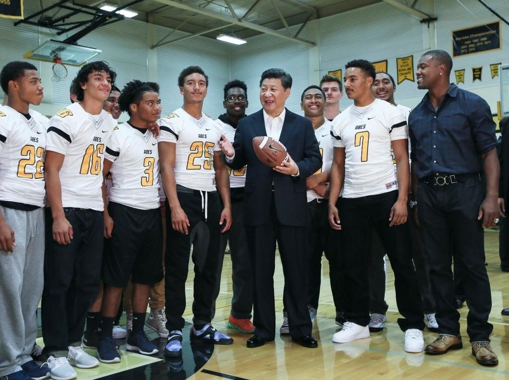 2015年9月23日，國(guó)家主席習(xí)近平參觀美國(guó)塔科馬市林肯中學(xué)。這是習(xí)近平在學(xué)校體育館，同上橄欖球訓(xùn)練課的學(xué)生們親切交談。新華社記者 蘭紅光 攝