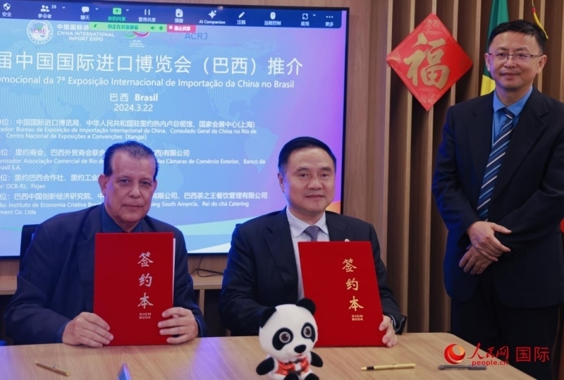 巴西外貿(mào)商會聯(lián)合會會長阿代爾·羅伯托（左）與中國國際進(jìn)口博覽局副局長吳政平（中）現(xiàn)場簽訂協(xié)議。人民網(wǎng)記者 宋亦然攝