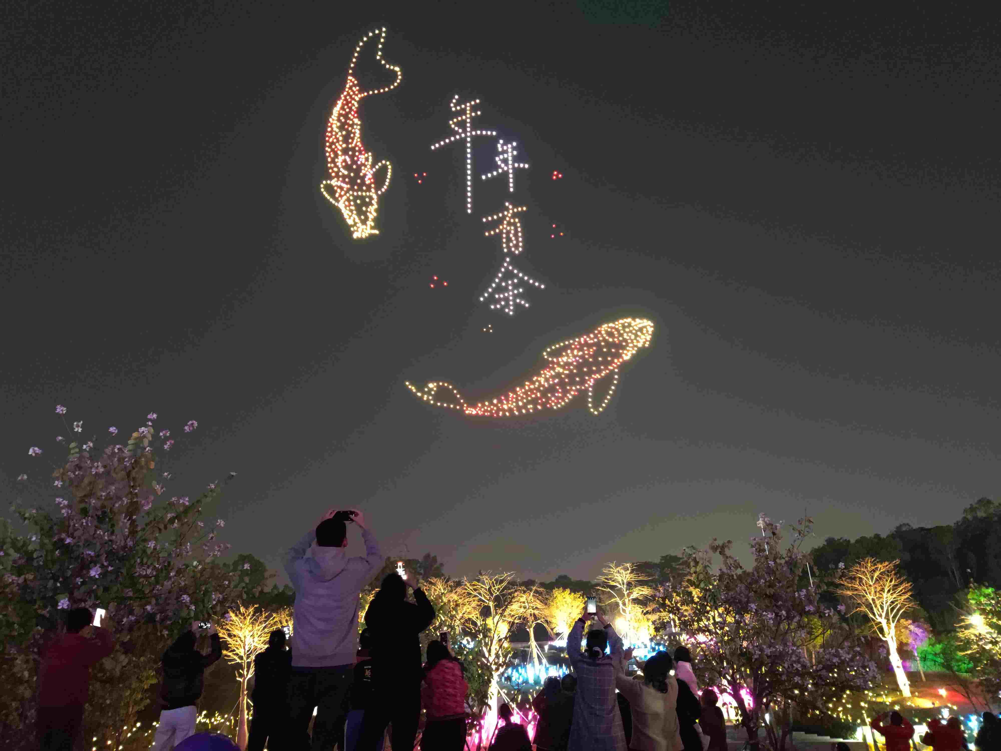 △ 2024年2月10日，深圳北站中心公園，春節(jié)主題無人機(jī)燈光秀引來眾多游客駐足觀看。