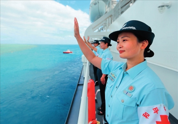 中國(guó)海軍“和平方舟”號(hào)醫(yī)院船結(jié)束訪問(wèn)湯加時(shí)，任務(wù)官兵中的文職人員向歡送人群揮手告別（2023年8月4日攝）。徐巍攝/本刊