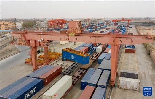 4月21日，二連浩特鐵路口岸龍門(mén)吊吊裝中歐班列集裝箱（無(wú)人機(jī)照片）。 新華社發(fā)（張海峰攝）