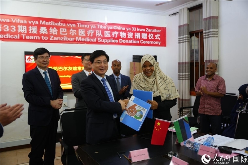 江蘇省蘇北人民醫(yī)院黨委書記束余聲與桑衛(wèi)生部首席秘書哈比巴交換捐贈書。中國援桑醫(yī)療隊(duì)供圖