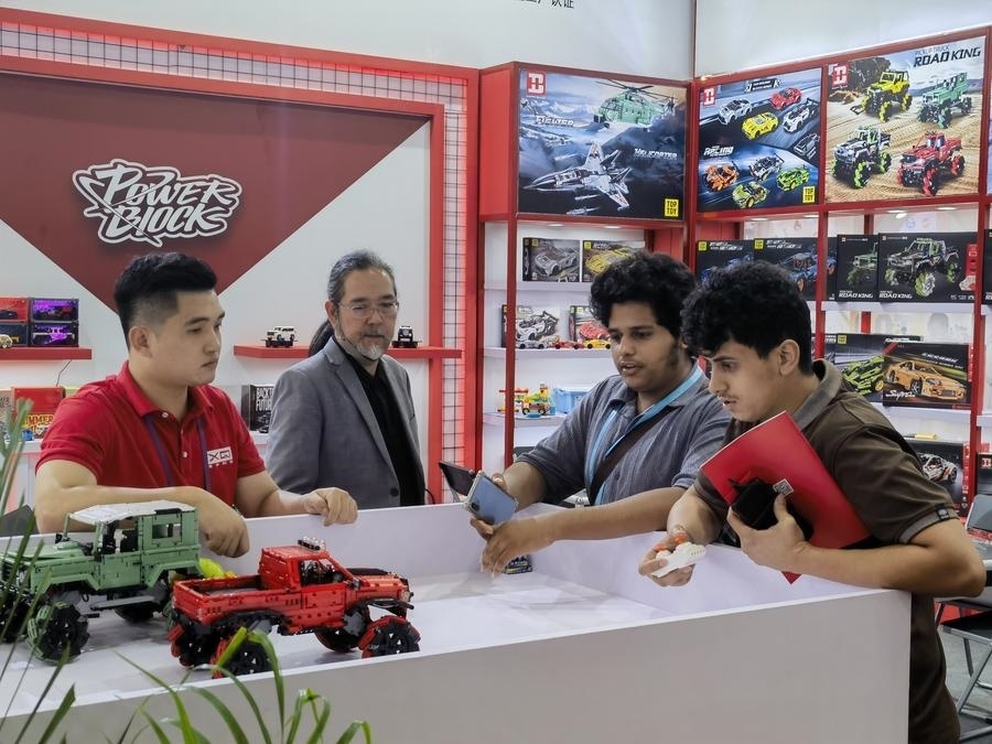 在第135屆廣交會(huì)第三期現(xiàn)場(chǎng)，采購商在廣東信宇科技股份有限公司展位選購、體驗(yàn)積木遙控車產(chǎn)品（5月2日攝）。新華社記者 洪澤華 攝