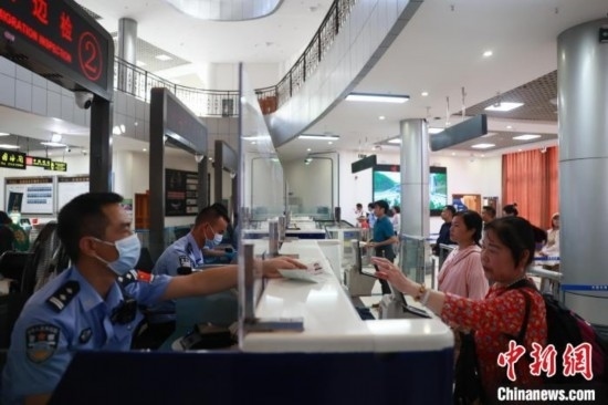 圖為旅客在磨憨口岸辦理通關(guān)手續(xù)。雷雨 攝