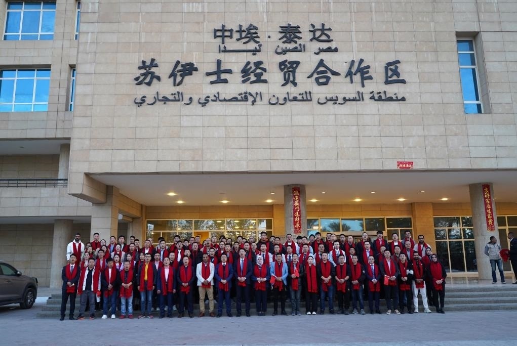 2024年2月11日，在位于埃及蘇伊士省的中?！ぬ┻_蘇伊士經(jīng)貿(mào)合作區(qū)，中埃員工在合作區(qū)辦公大樓前合影拜年。新華社發(fā)（泰達合作區(qū)供圖）