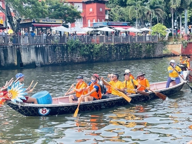 多元種族共同奮輯前進(jìn)，體驗(yàn)在馬六甲河劃龍舟，引來(lái)大批游客駐足圍觀。組委會(huì)供圖