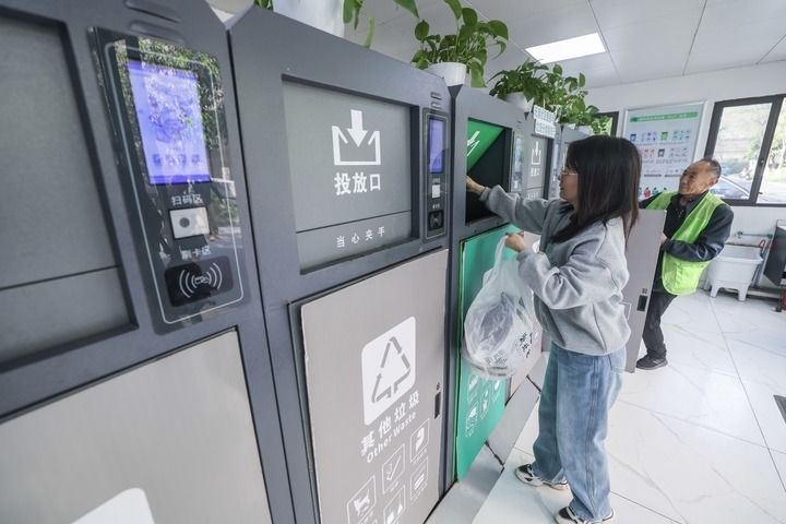 2024年4月10日，在浙江省湖州市吳興區(qū)飛英街道新華府小區(qū)內，居民在垃圾分類智能系統(tǒng)的指導下進行垃圾分類投放，居民的投放情況將實時匯總到智慧服務平臺，會有相應的積分獎勵。新華社記者 徐昱 攝
