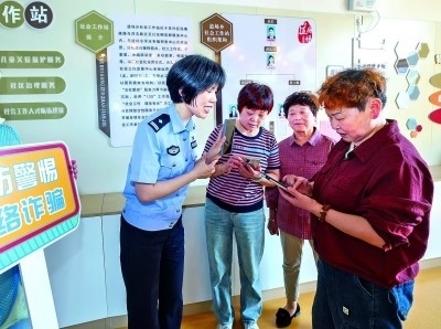 浙江湖州民警指導居民加入湖州“e企安”微信群，實時接收反詐信息。新華社發(fā)
