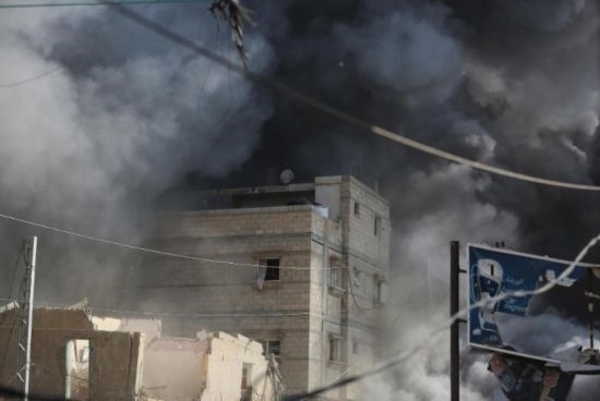 7月21日，在加沙地帶中部的努賽賴特難民營，遭以軍空襲的建筑冒出滾滾濃煙。新華社發(fā)（馬爾萬·達烏德攝）