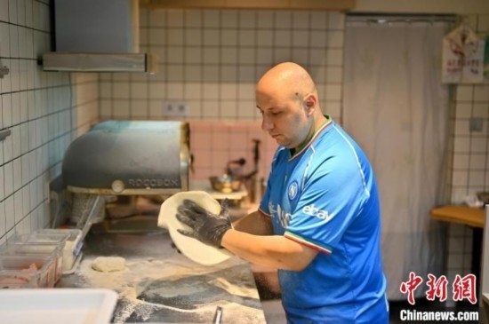 近日，韋榮耀在自家披薩小店內(nèi)忙活。俞靖 攝