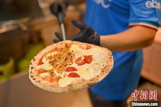 近日，韋榮耀展示他制作的“老友味”披薩。 俞靖 攝