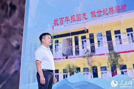 張玉滾分享用一根扁擔(dān)送孩子們走出大山的故事。人民網(wǎng)攝