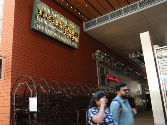 2023年5月29日，人們經(jīng)過美國紐約曼哈頓的“國債鐘”?！皣鴤姟笔且粋€(gè)大型計(jì)數(shù)器，它實(shí)時(shí)更新美國的公共債務(wù)總額，并顯示出每個(gè)美國家庭所要負(fù)擔(dān)的數(shù)額。 新華社記者劉亞南攝