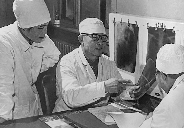 1980年1月16日，中日友好醫(yī)院首任院長辛育齡（中）在內(nèi)蒙古結(jié)核病院與胸外科醫(yī)師討論病例（翻拍照片）。 新華社發(fā)