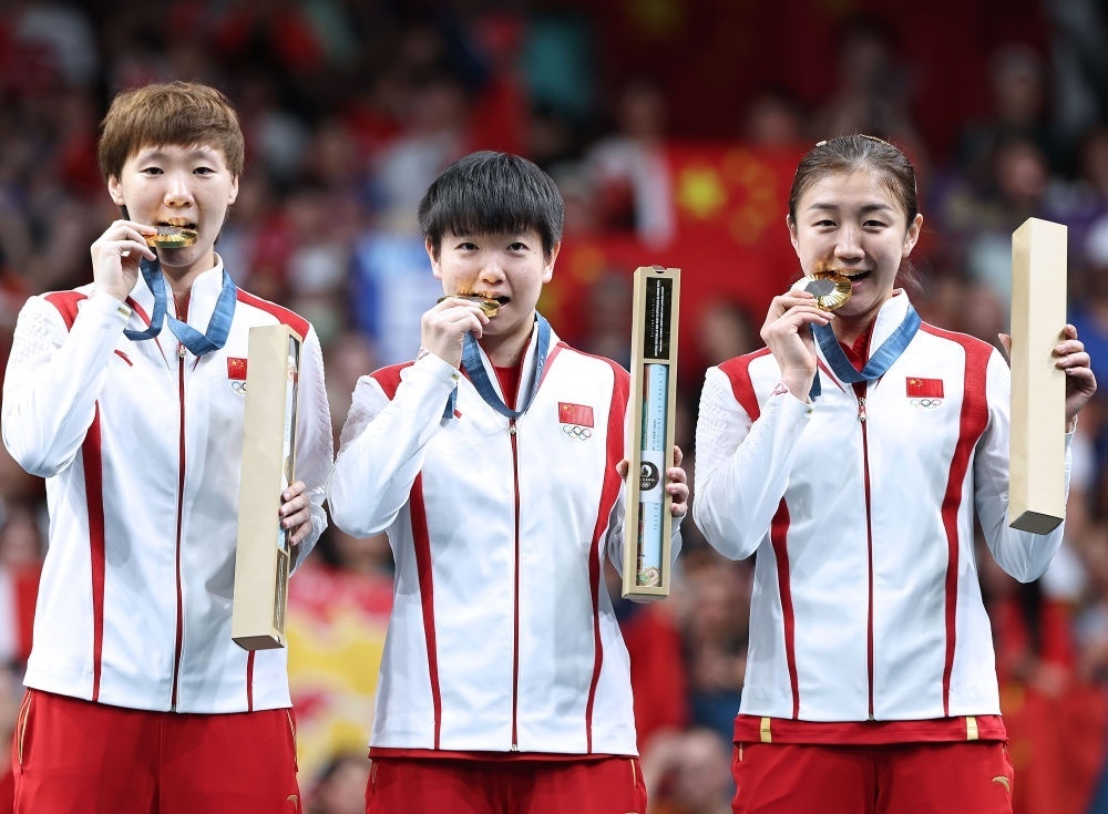 冠軍中國隊(duì)選手王曼昱、孫穎莎、陳夢(mèng)（從左至右）在巴黎奧運(yùn)會(huì)乒乓球女子團(tuán)體頒獎(jiǎng)儀式上（2024年8月10日攝）。新華社記者 王東震 攝