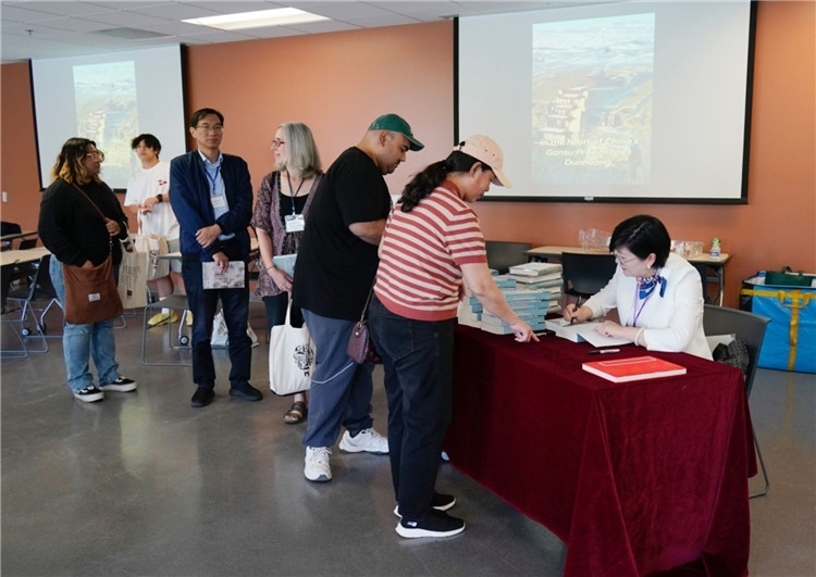 作者顧春芳在活動(dòng)現(xiàn)場(chǎng)簽名贈(zèng)書(shū)。羅先勇攝