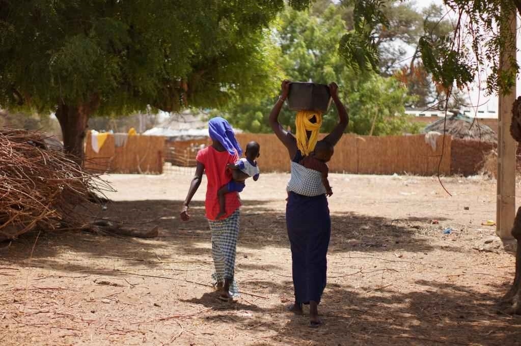 2023年3月20日，在塞內(nèi)加爾久爾貝勒區(qū)的泰內(nèi)富勒村，村民將取到的水運回家。新華社記者 王子正 攝