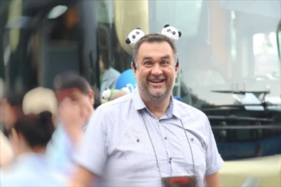 參訪熊貓谷前，塞爾維亞“一帶一路”研究所所長博揚·拉利奇戴上熊貓頭飾。（李佩藺 攝）