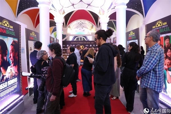 為期4天的第三屆中國(guó)－巴西電影展期間，來(lái)自中巴兩國(guó)的14部參展影片受到巴西電影愛好者和社會(huì)各界人士好評(píng)，圖為當(dāng)?shù)赜^眾在影展舉辦地巴西里約熱內(nèi)盧勞拉—阿爾維姆文化之家的迎賓廳欣賞參展電影海報(bào)。 人民網(wǎng)記者 陳一鳴攝