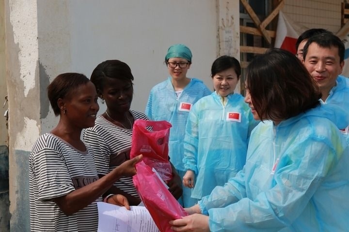 2015年4月4日，在位于塞拉利昂首都弗里敦市郊的中塞友好醫(yī)院埃博拉診療中心，中國第四批援塞醫(yī)療隊副隊長邵蔚（右前）向被治愈的埃博拉出血熱患者贈送禮物。新華社發(fā)（祖榮強 攝）