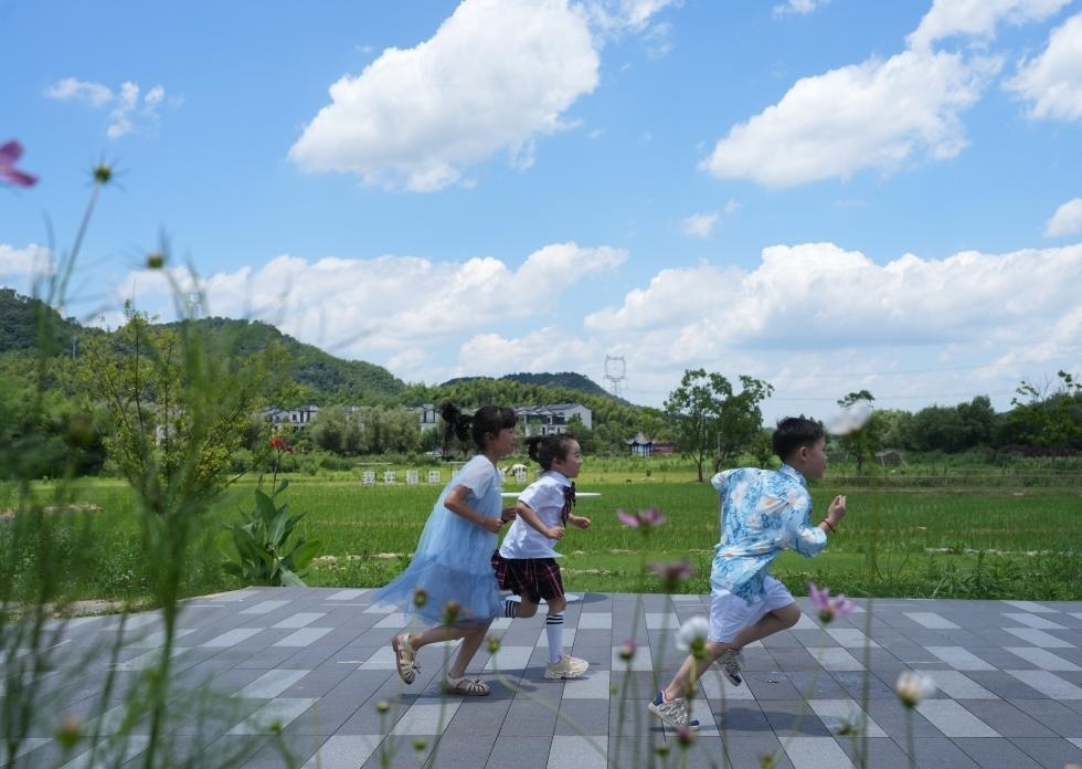 兒童在余姚市梁弄鎮(zhèn)的田野間奔跑（7月3日攝）。新華社記者翁忻旸 攝