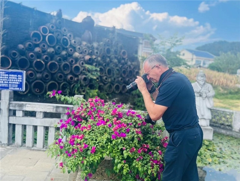 遠(yuǎn)處黔北民居錯(cuò)落有致，近處一只黑色的蝴蝶穿梭于粉紫色三角梅花叢間隙，與俄羅斯“大歐亞”總編輯弗拉基米爾·別列日內(nèi)赫的鏡頭玩起了捉迷藏，“你追我逃，不亦樂(lè)乎”。（張亞欣攝）