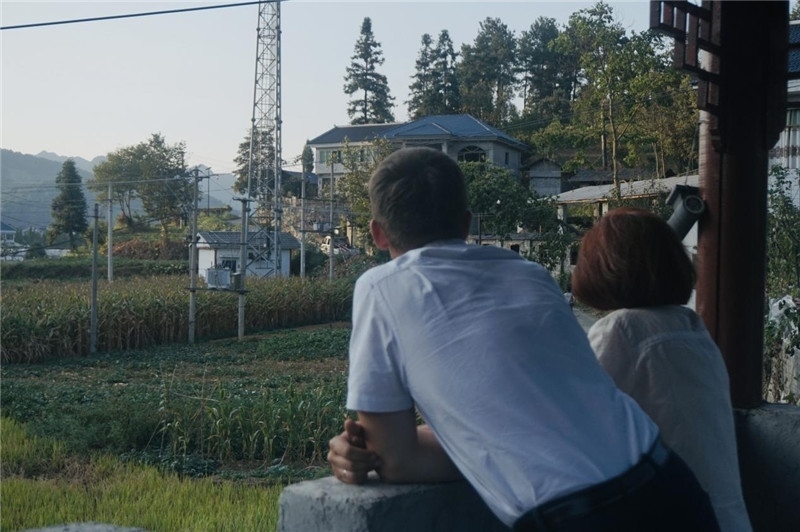 望得見(jiàn)山，看得見(jiàn)水，記得住鄉(xiāng)愁。每個(gè)人心中都有一個(gè)屬于自己的“花茂村”，在這方心田，走遍千山萬(wàn)水，鄉(xiāng)音未改鬢毛衰。吉爾吉斯斯坦《比什凱克晚報(bào)》第一副總編輯妮娜·尼奇博洛娃與《中國(guó)與俄羅斯》雜志社社長(zhǎng)奧列格·別列日內(nèi)赫攝在花茂村民居屋檐下并肩佇立，眺望山水，尋覓鄉(xiāng)愁。（李光裕攝）