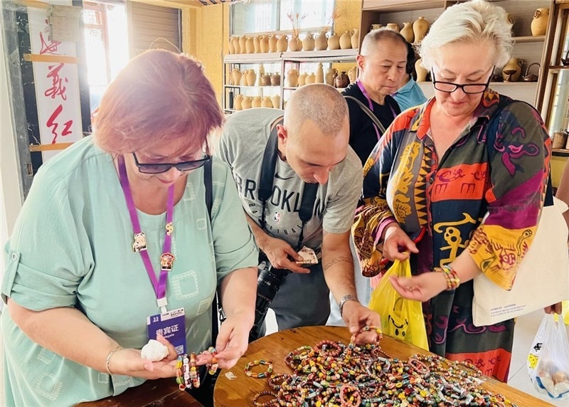 歐亞媒體考察團(tuán)成員在母氏陶藝館內(nèi)挑花了眼，色彩絢麗、質(zhì)地均勻的陶藝手串讓他們愛(ài)不釋手?！斑@里的東西都太實(shí)惠了！”塔吉克斯坦《索格特真理報(bào)》政論部主任娜塔利婭·多羅費(fèi)耶娃說(shuō)?；宓奶厣a(chǎn)品物美價(jià)廉，讓考察團(tuán)成員為家人好友買到了心儀的禮物，也為此次以四川成都為起點(diǎn)，路經(jīng)南充、廣安至貴州遵義的考察行程畫上了圓滿句號(hào)。（張亞欣攝）