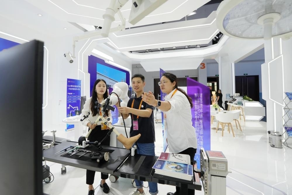 9月11日，一位媒體記者（中）在2024年服貿(mào)會(huì)國家會(huì)議中心會(huì)場體驗(yàn)北京納通科技集團(tuán)有限公司的膝關(guān)節(jié)置換手術(shù)機(jī)器人。新華社記者鞠煥宗 攝