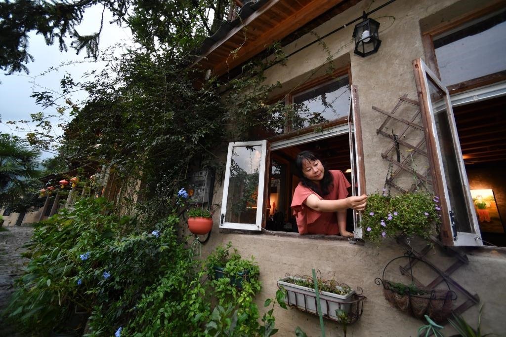 8月29日，在福建省屏南縣熙嶺鄉(xiāng)，龍?zhí)洞濉靶麓迕瘛泵泛暝诖蚶碜约航洜I的民宿外墻裝飾花盆。新華社記者姜克紅 攝