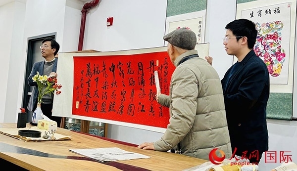 旅秘書法家向現(xiàn)場(chǎng)觀眾展示書法作品。人民網(wǎng)記者 宋亦然攝