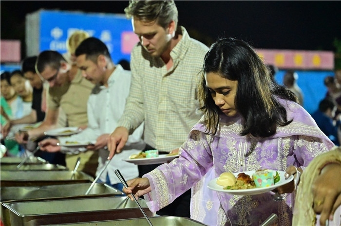 外國(guó)友人品嘗中國(guó)美食。馬騫攝