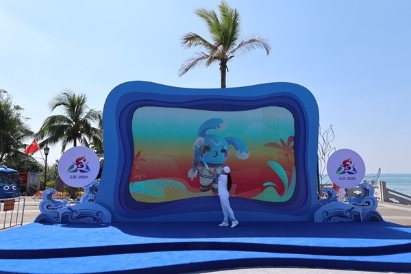 第12棒火炬手“點燃”現(xiàn)場大屏幕上運動會吉祥物“吉貝”手中的火炬。主辦方供圖