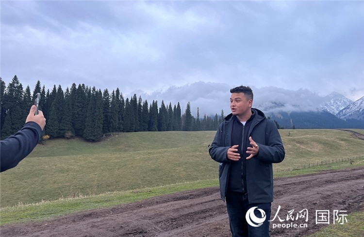 在庫爾德寧，吾買爾江被雪山美景震撼，即興錄制了短視頻作品。人民網(wǎng)記者曾書柔攝