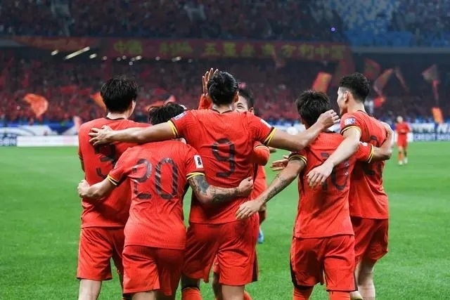 10月15日晚，張玉寧（9號(hào)）進(jìn)球后與隊(duì)友擁抱慶祝。新華社記者 李紫恒攝