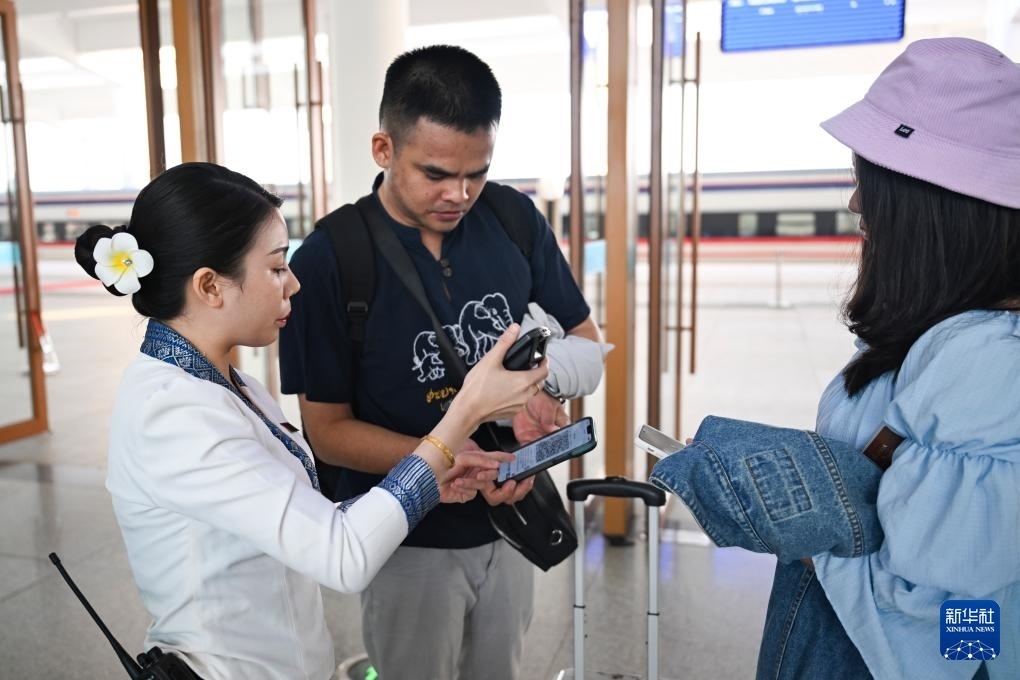 10月12日，在老撾萬象中老鐵路萬象站，工作人員檢驗乘客車票。新華社記者 程一恒 攝