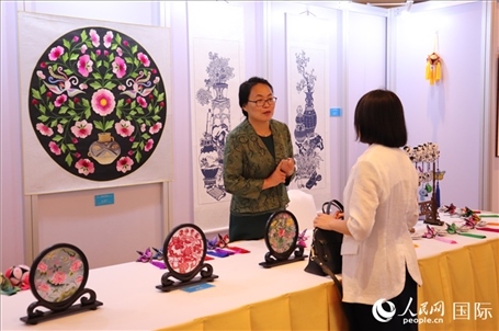 青海非遺文化傳承人向嘉賓介紹展品。人民網(wǎng)實習(xí)生姚欣可攝