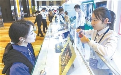 在北京麗澤商務(wù)區(qū)，工作人員（右一）介紹數(shù)字人民幣SIM卡硬錢包。新京報(bào)記者 陶冉攝